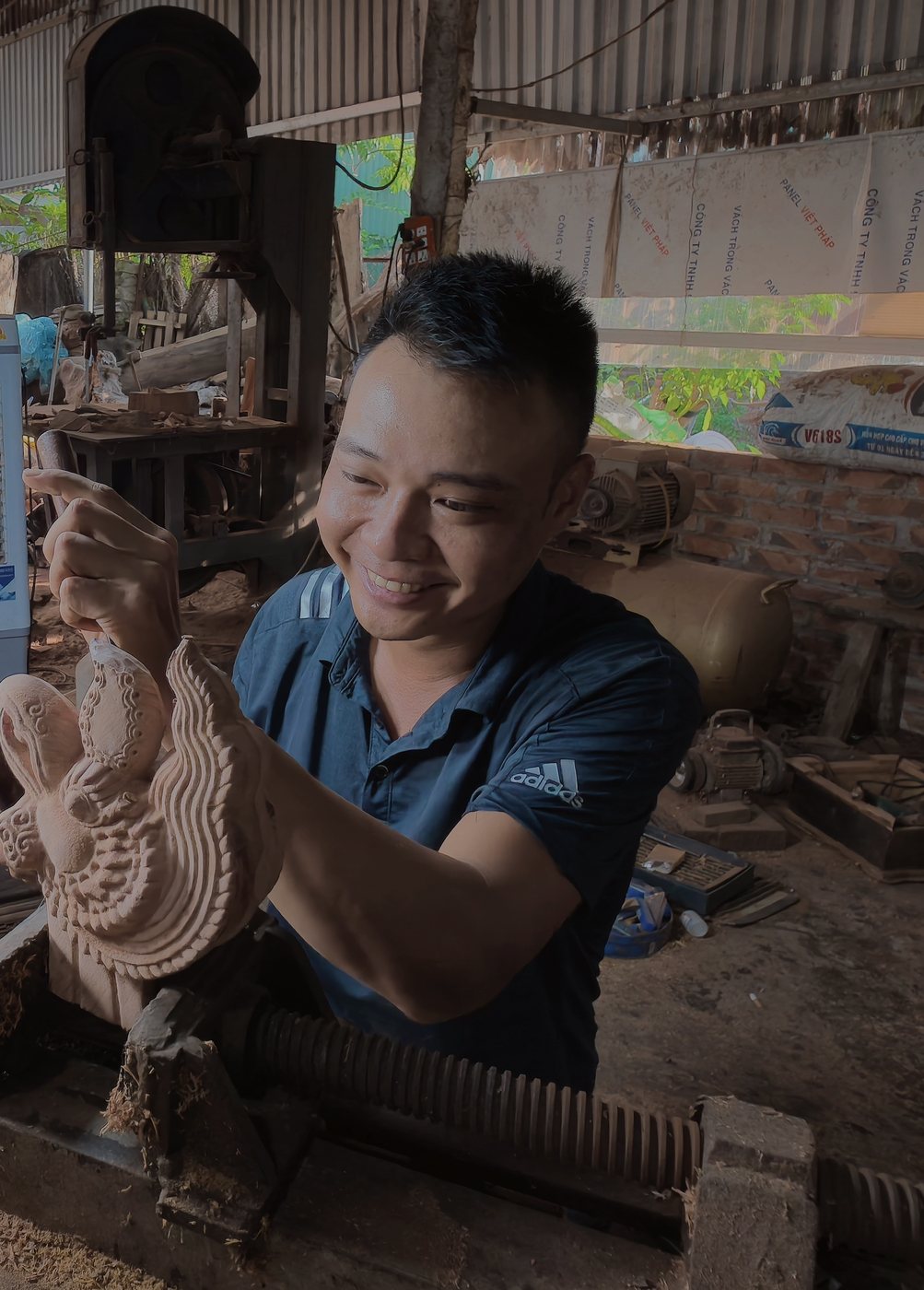 Nghệ nhân đang tỉa chi tiết tác phẩm Phượng tại xưởng Đông Giao